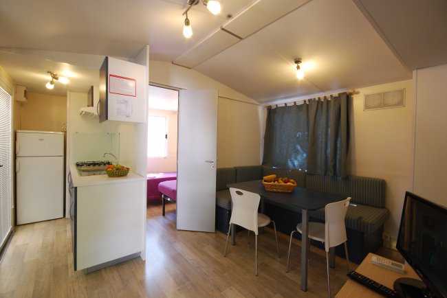 Soggiorno con cucina, tavolo e divano.