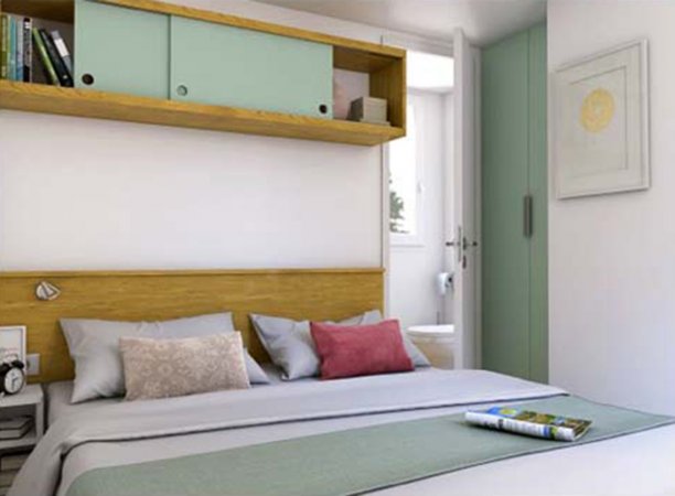 Camera da letto matrimoniale con mensola sopra il letto.