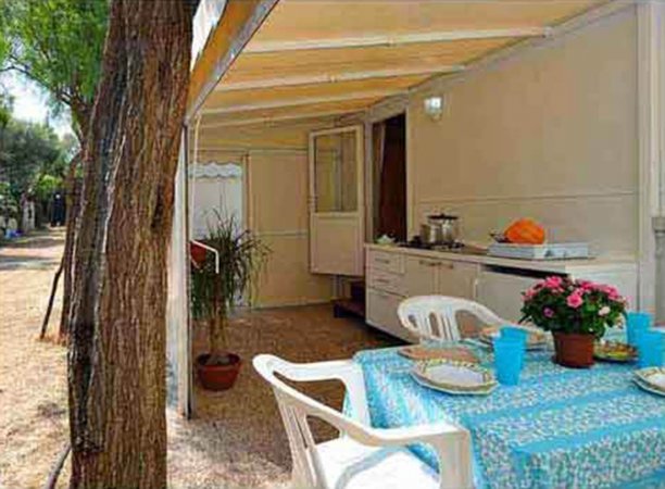Veranda esterna con tavolo apparecchiato.