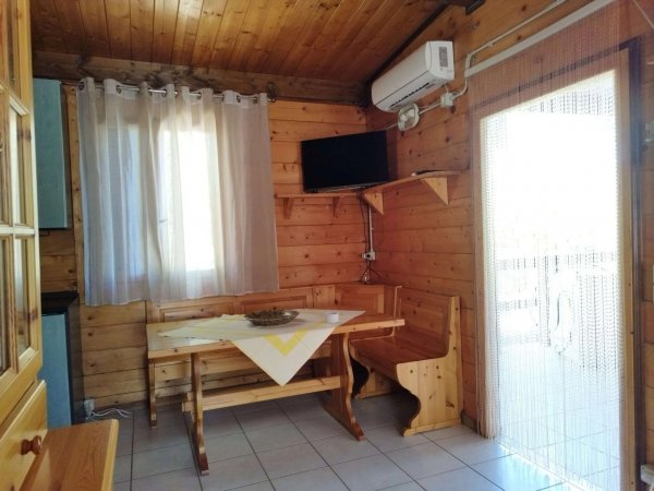 Interno di una cabina in legno con tavolo e TV.