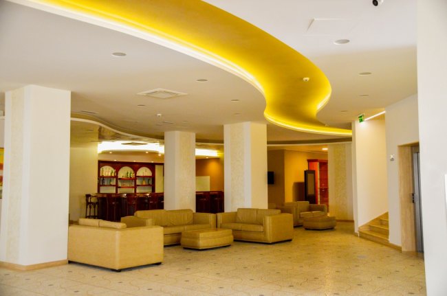Un salotto moderno con divani beige e illuminazione soffusa.