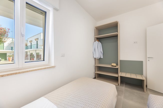 Camera con finestra, armadio e letto.