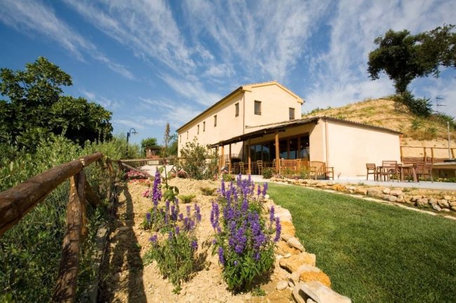Edificio rustico con giardino fiorito.