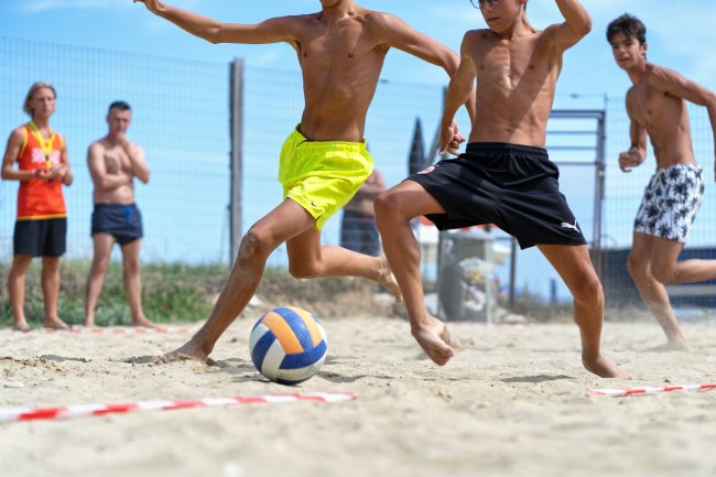 Partita di calcio sulla spiaggia con ragazzi in movimento.