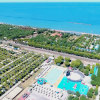 Vista aerea di un litorale con campeggio, strade e piscina vicino al mare.