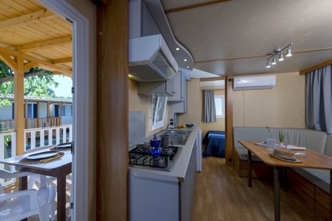 Interno di una casa mobile con cucina, tavolo e divano.