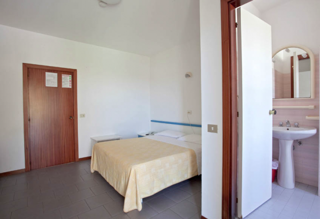 Una camera da letto semplice con letto matrimoniale e bagno privato.