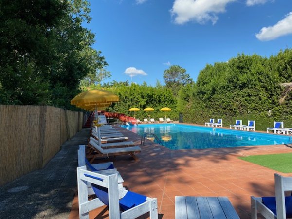 Piscina con ombrelloni gialli e sedie a sdraio.