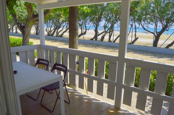 Veranda con vista mare, tavolo e sedie.