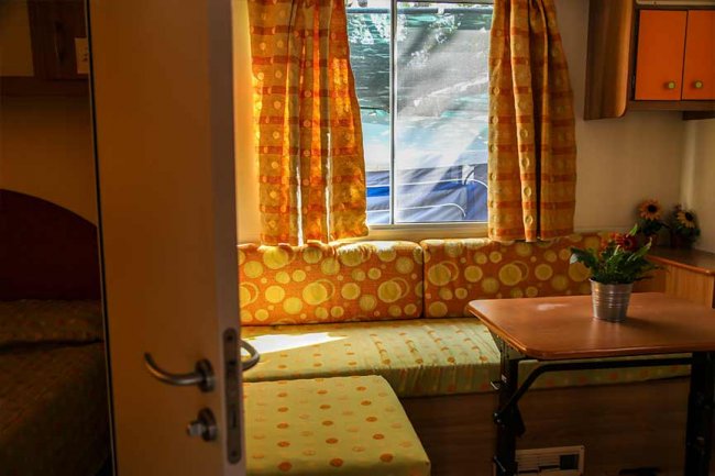 Interno colorato con divano a motivi gialli e tende abbinate.