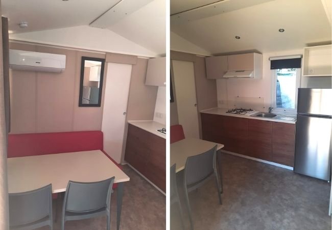 Interno di una cucina e area pranzo con mobili moderni, tavolo e sedie.