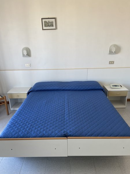 Letto matrimoniale con copriletto blu.