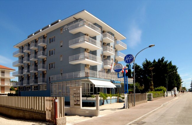 Facciata laterale di un hotel blu con balconi e insegna 
