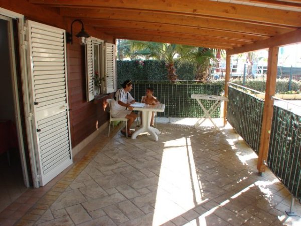 Una veranda coperta con tavolo bianco.