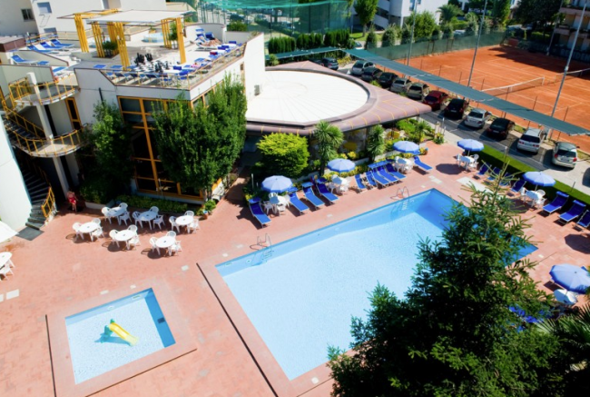 Vista dall'alto di una piscina con lettini e ombrelloni.