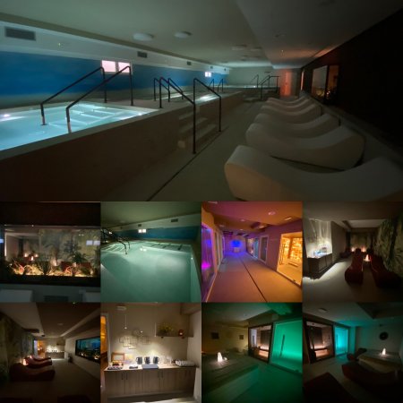Interno di una spa con piscina, sedie a sdraio e illuminazione soffusa.