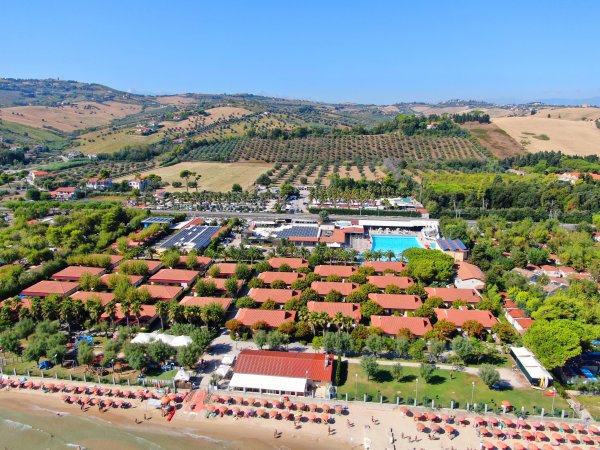 Vista aerea di un resort con villette e piscina.
