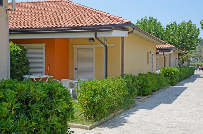 Villette a schiera con tetti rossi e giardino curato.