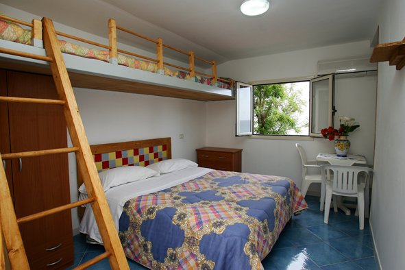 Stanza con letto matrimoniale e soppalco.