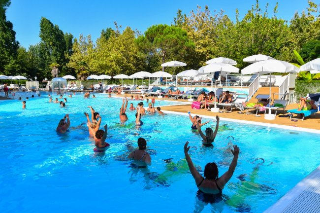 Un gruppo di persone in acqua che partecipa a una lezione di aquagym in piscina.