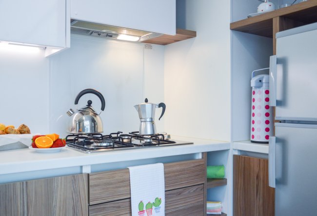 Cucina moderna con teiere e moka su fornelli a gas.