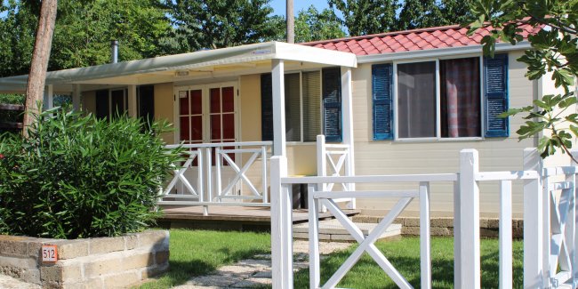 Casa mobile con veranda coperta e giardino in primo piano.