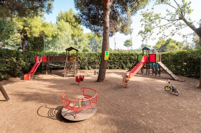 Parco giochi con scivoli, giostra e giochi per bambini.