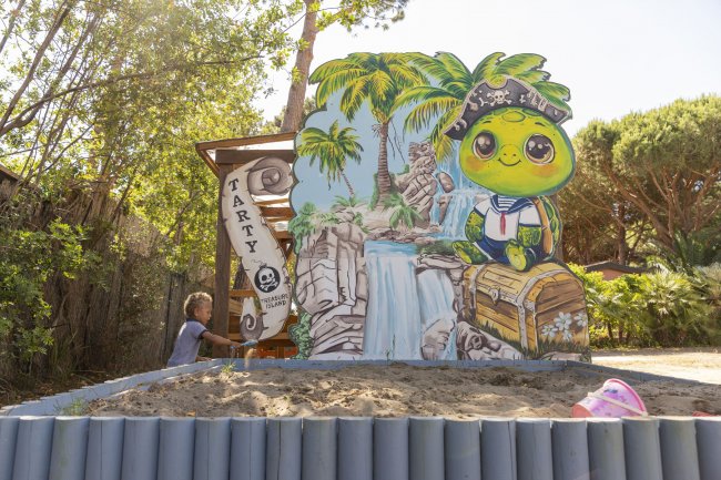 Bambino con cartonato di tartaruga pirata e cascata.