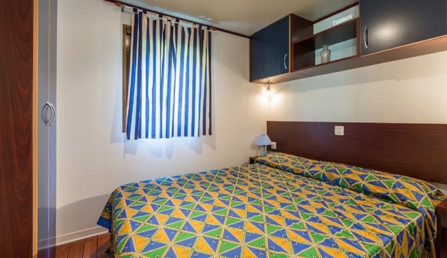 Camera da letto con copriletto colorato.