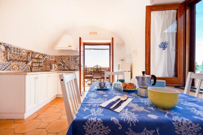Cucina luminosa con tavolo apparecchiato.