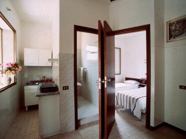 Cucina e camera da letto con porta aperta.