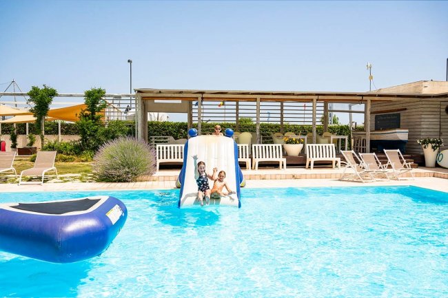Bambini scivolano in piscina.