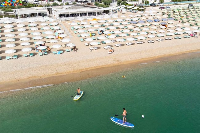 Vista aerea di due persone su paddle board in mare.