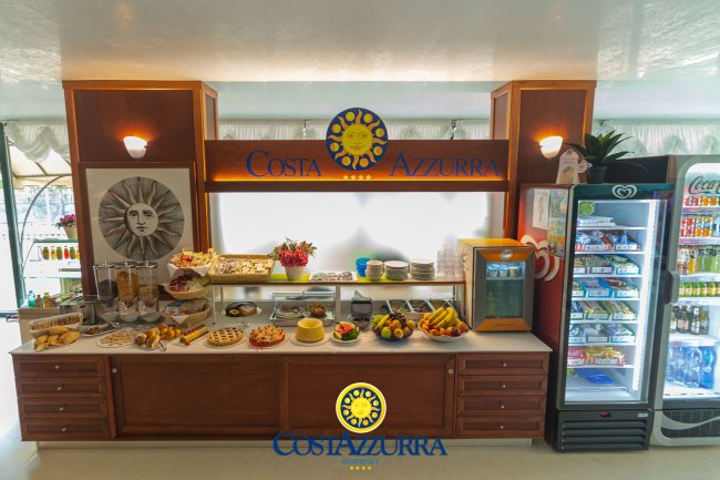 Buffet con cibi assortiti e bevande, decorato con insegna 