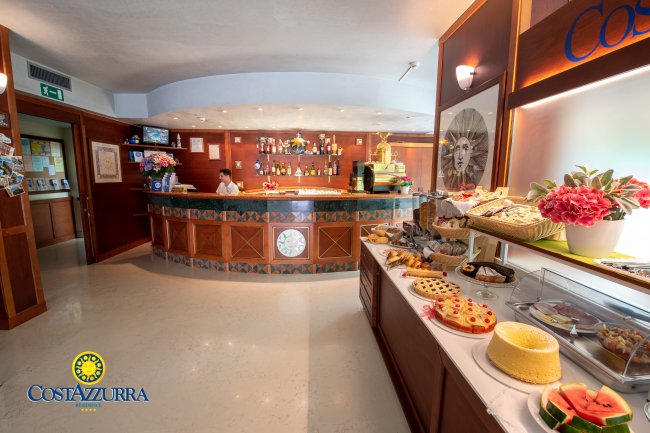 Reception di un hotel con bancone e buffet dolci.