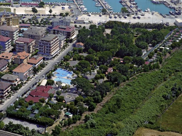 Vista aerea di un'area residenziale con piscina, vicino a un porto turistico.