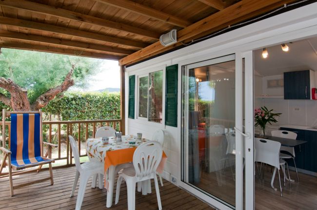 Veranda con tavolo apparecchiato e sdraio.