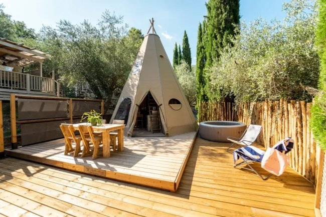 Tenda a forma di tipì su una terrazza in legno.