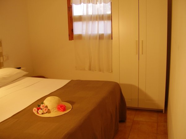 Camera da letto con letto matrimoniale e armadio bianco.