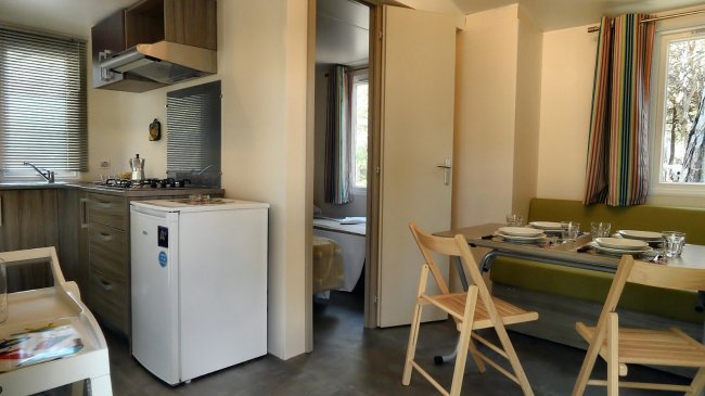 Cucina adiacente alla sala da pranzo con piccola porta per la camera da letto.