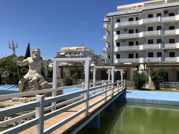 Statua di Nettuno vicino a un edificio moderno.