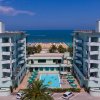 Edificio con piscina e vista mare, cielo limpido.