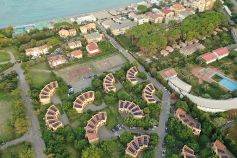 Vista aerea di un villaggio con case e piscina.