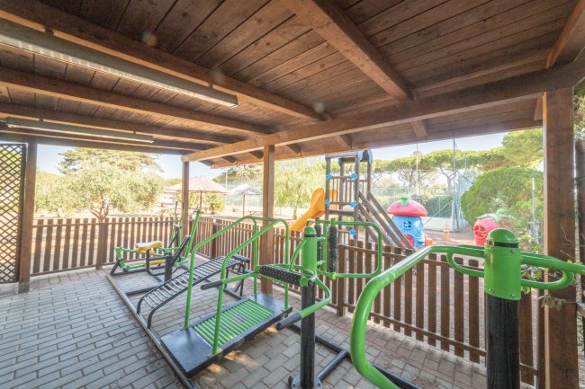 Attrezzi fitness sotto tettoia di legno.