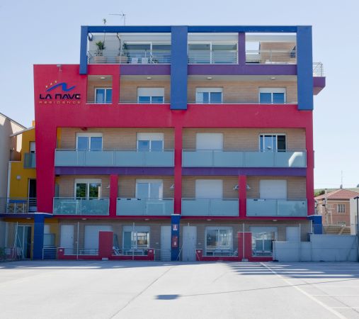 Edificio colorato a tre piani con balconi e insegna 