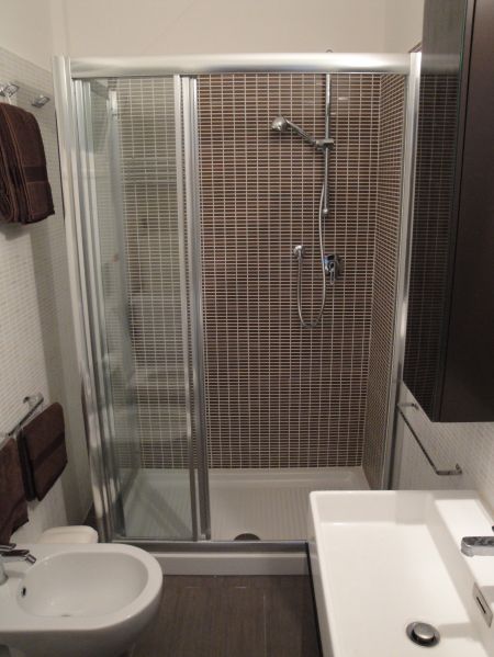 Bagno con doccia in vetro, lavandino e bidet.