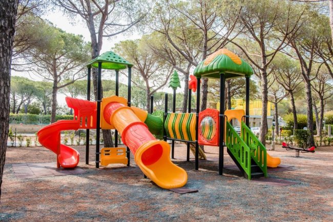 Parco giochi colorato con scivoli e altalene.