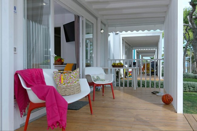 Veranda con sedie, tavolino, palla da basket e decorazioni colorate.