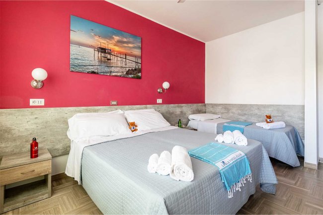 Camera con letto matrimoniale e parete rossa.