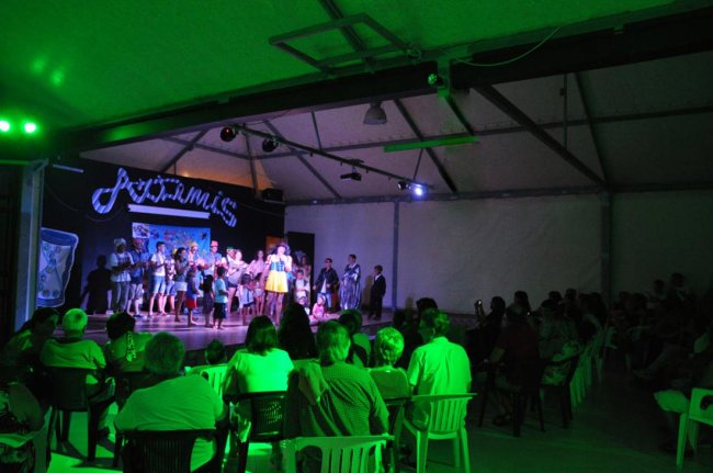 Spettacolo serale su un palco con il pubblico seduto.